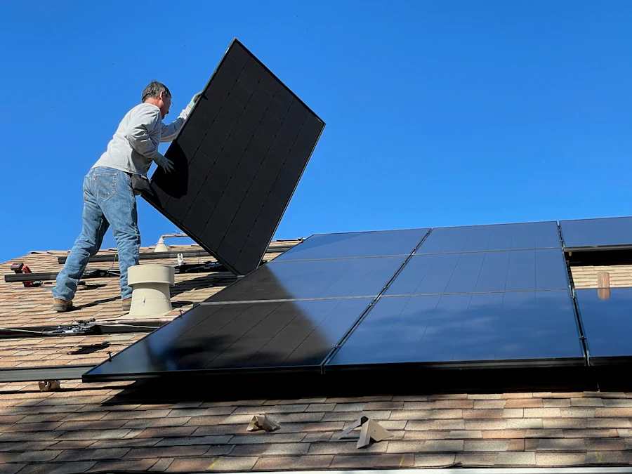 Installer placing a solar panel on a home roof